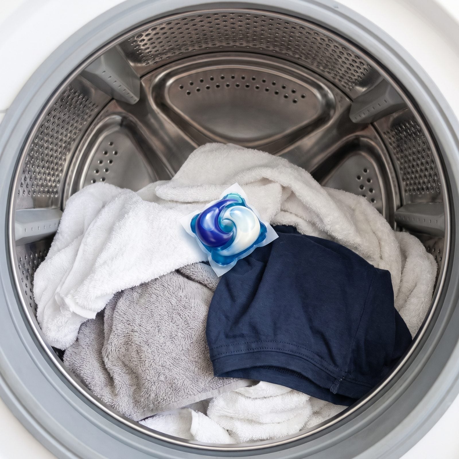 Placing a Laundry Pod on Top of the Clothes