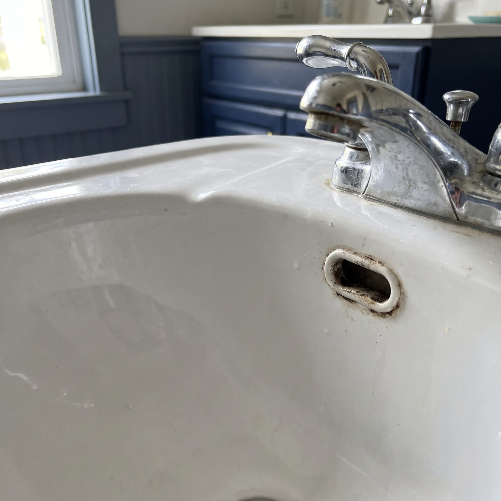 The Sink Overflow Opening Where Buildup Hides Beyond the Rim